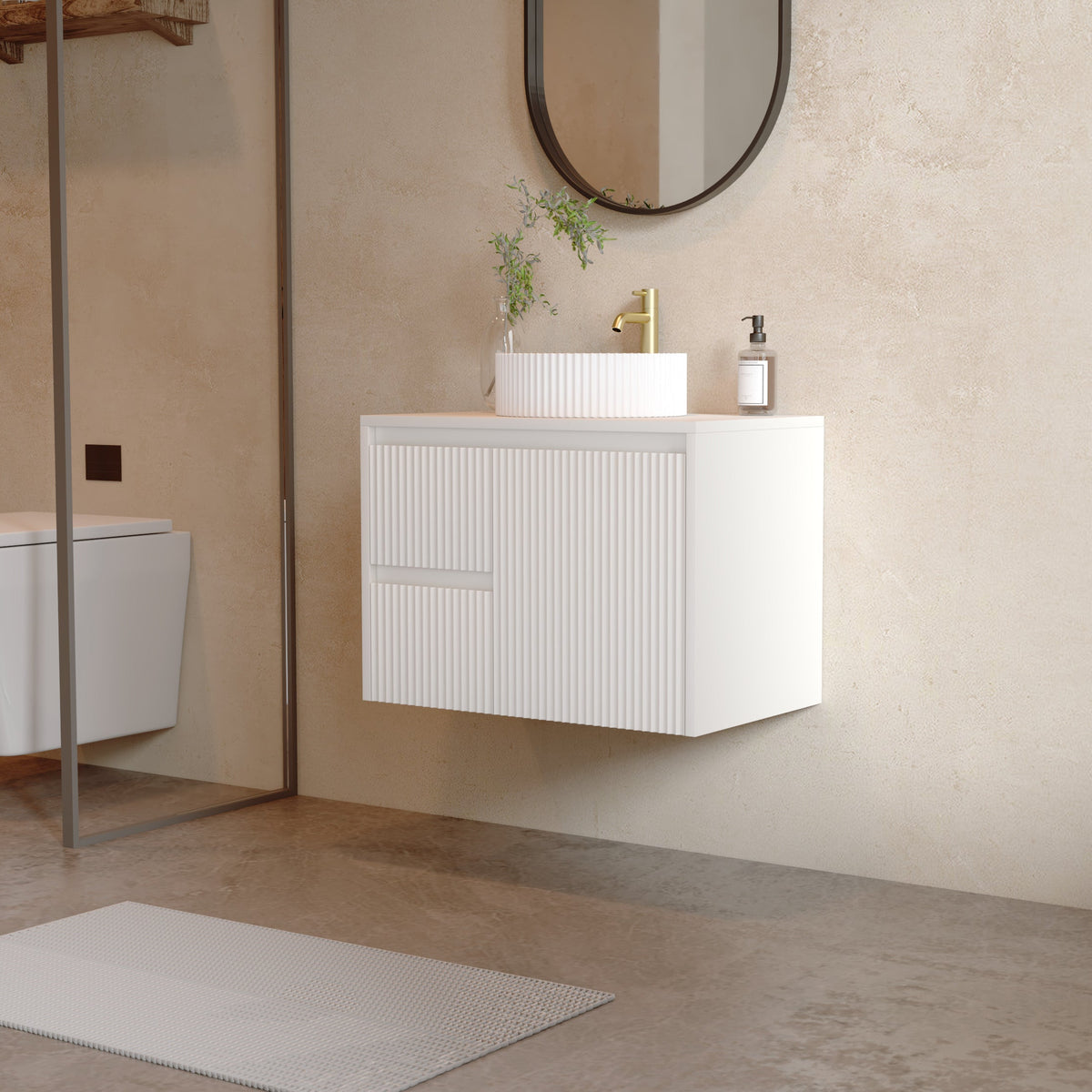 A modern floating bathroom vanity with a white ribbed cabinet, a white rectangular sink, and a gold faucet, shown in a minimalist beige-toned bathroom setting.