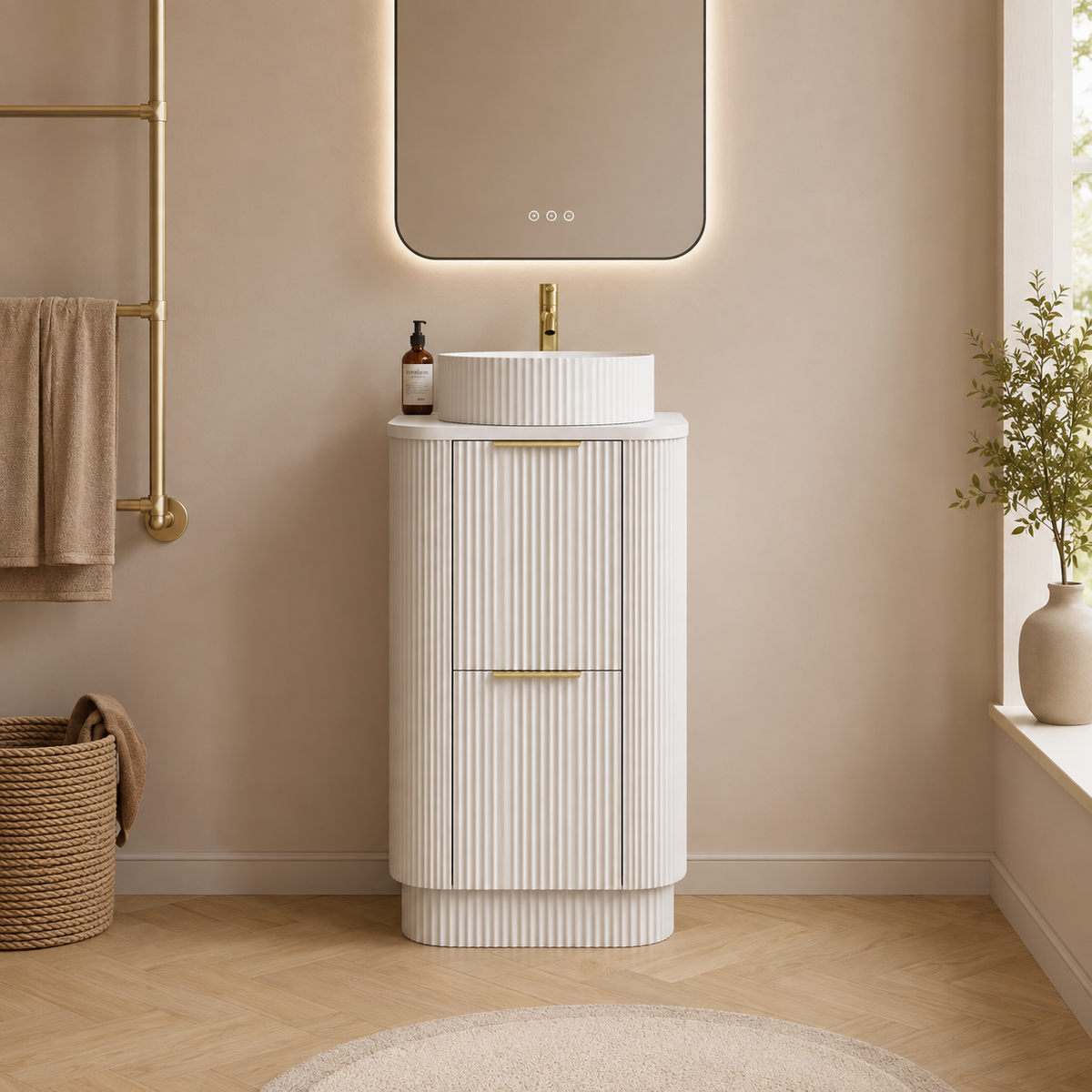 A modern white bathroom vanity cabinet with vertical fluted detailing, a matching round vessel sink, and gold hardware, set in a warm beige-toned bathroom with a mirror, towel rack, and wood floor.